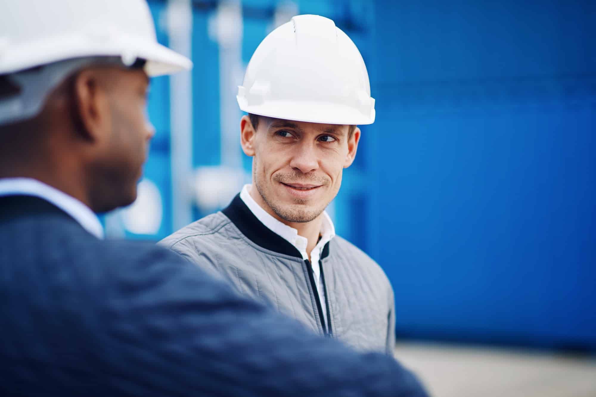 Port manager talking with an engineer in a shipping yard